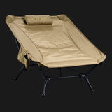 TieGear Base Lounger low-profile camp chair with hammock-style recline, lightweight frame, and durable fabric set up at a campsite.
