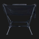 TieGear Base Lounger low-profile camp chair with hammock-style recline, lightweight frame, and durable fabric set up at a campsite.